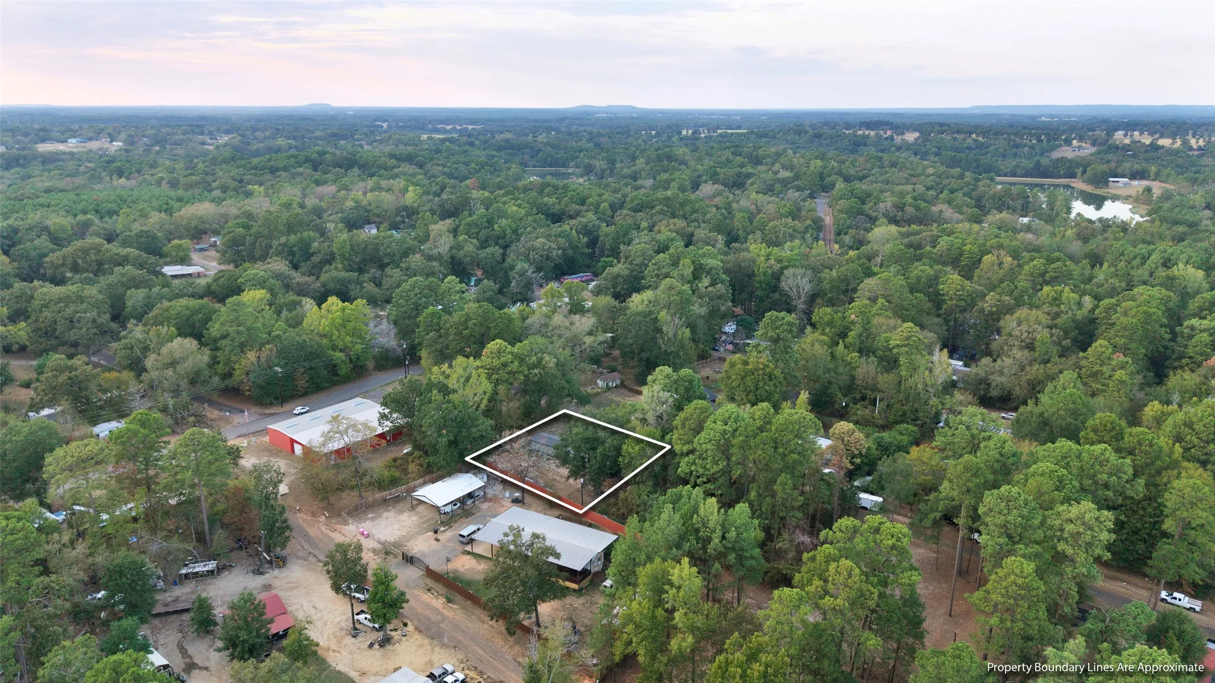 Wooded parcel with surrounding mature trees and distant water feature