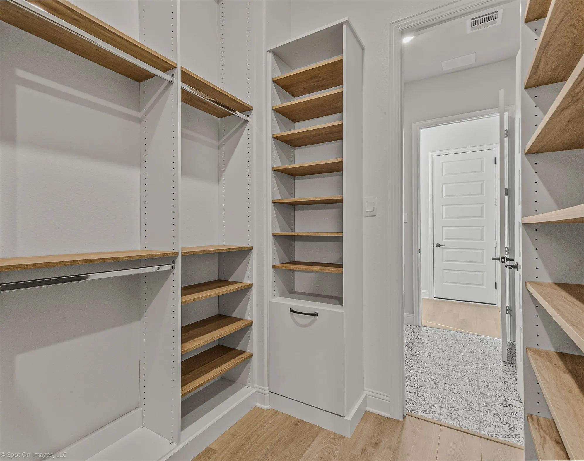 Integrated custom shelving, wood-finish flooring, built-in closet rods, and a paneled interior door