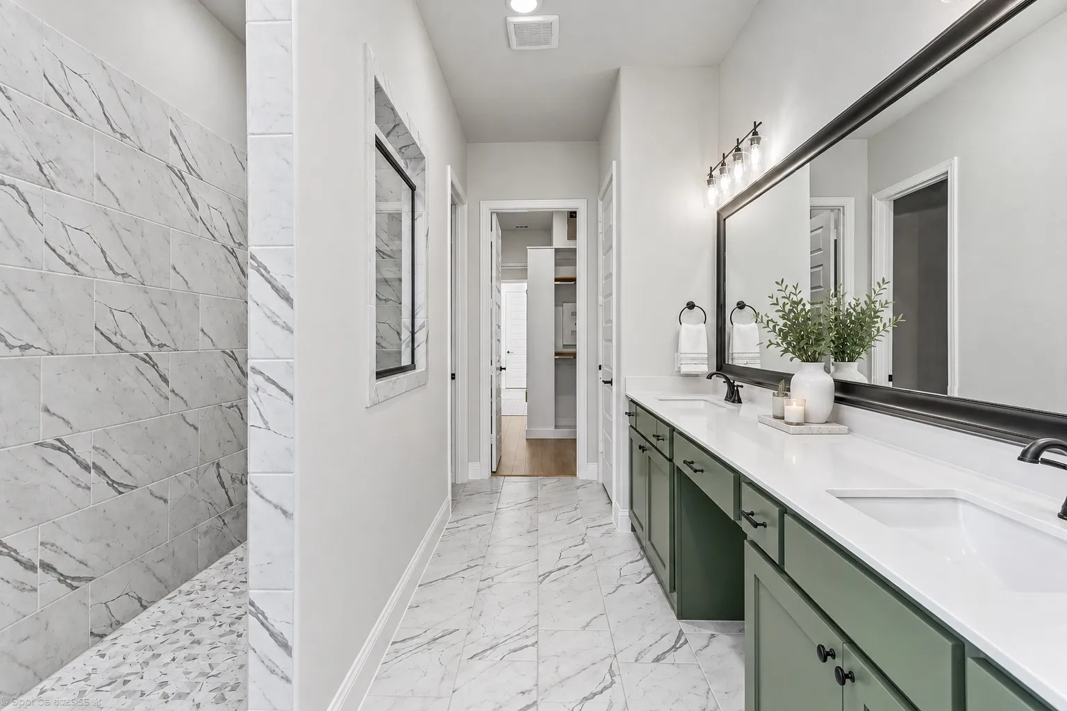 Walk-in shower with tiled walls and pebble-style floor