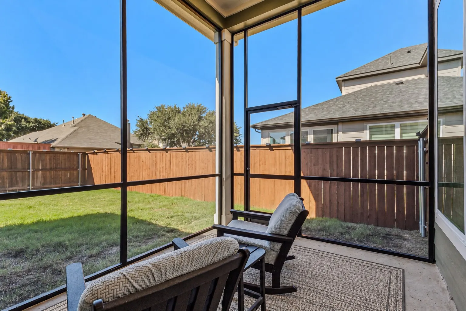 Screened patio with a concrete floor and a wood fence