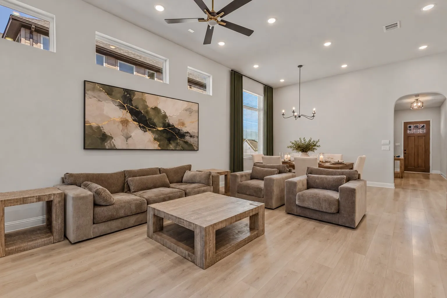 Spacious open-concept living area featuring high ceilings, recessed lighting, and wood-finish flooring