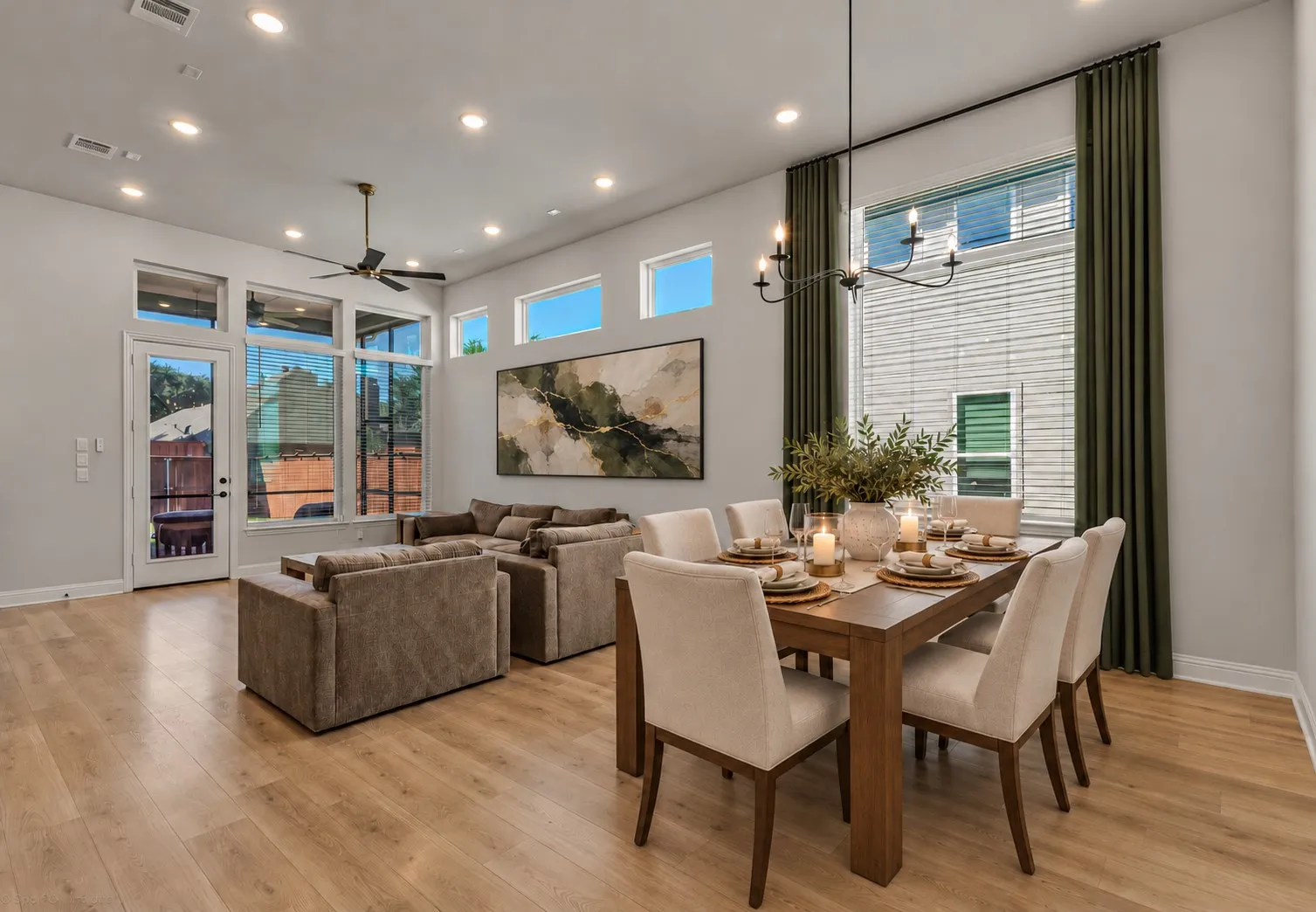 Open-concept living area featuring wood-finish flooring, recessed lighting, and a modern chandelier