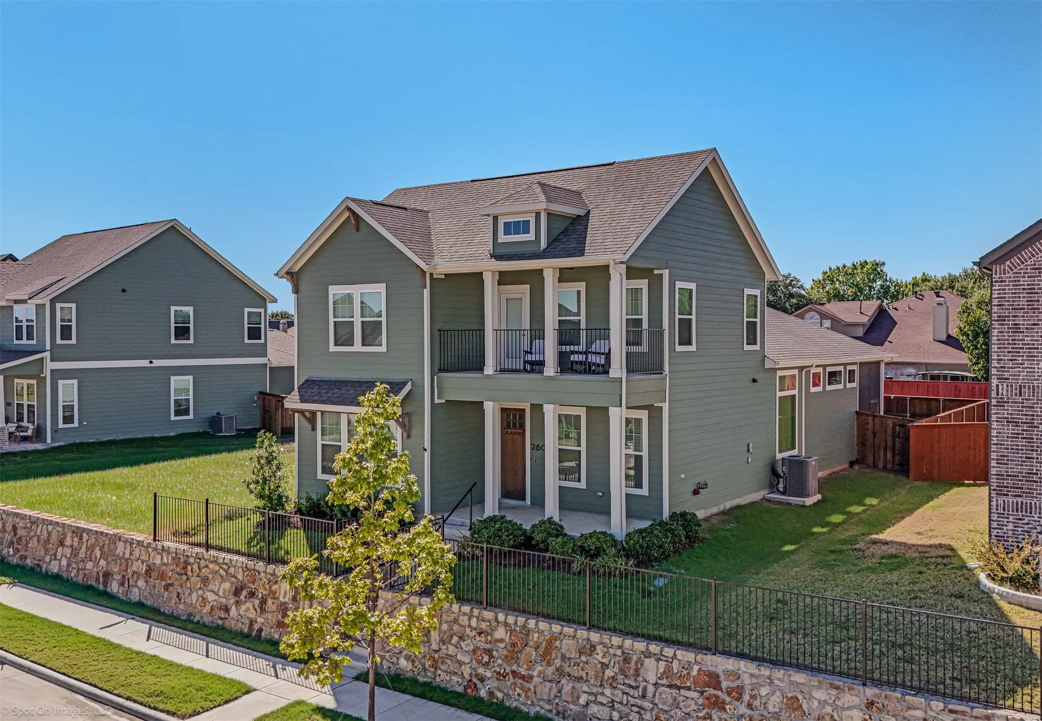 Two-story residence with a recessed balcony, covered entry, and dormer window