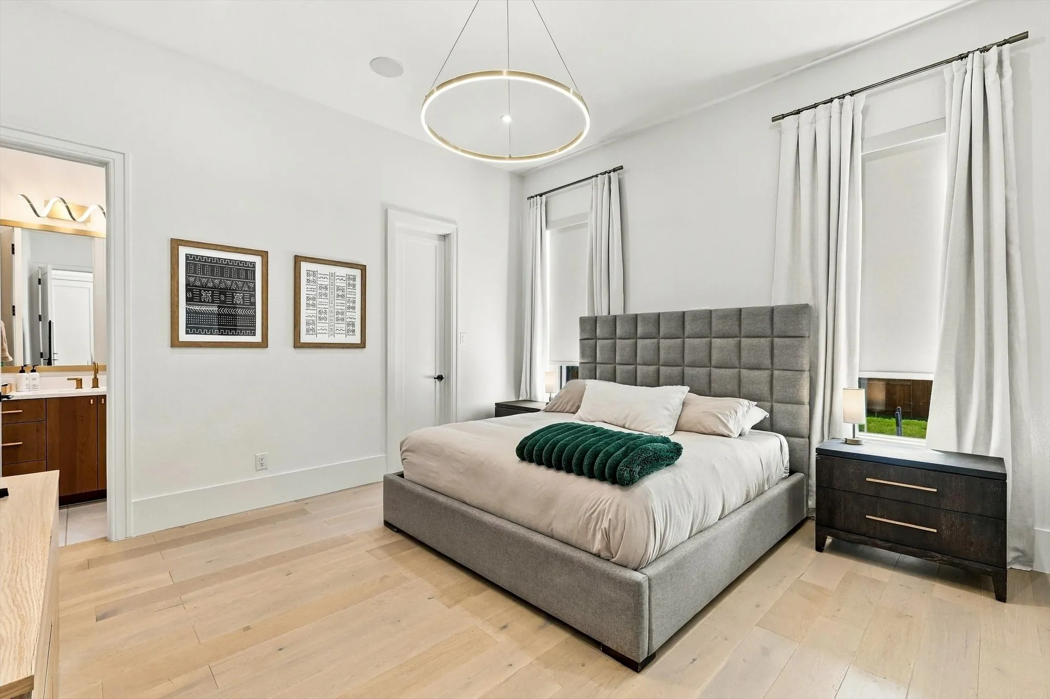 Light wood-finish flooring, recessed lighting, and a modern circular chandelier