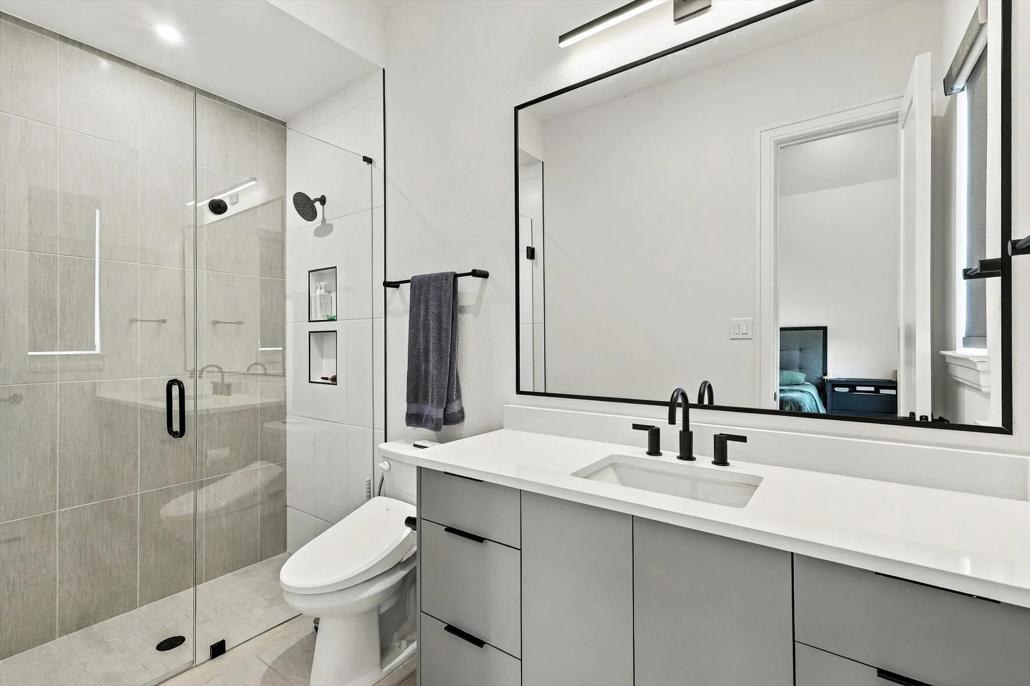 Glass-enclosed shower with tiled walls and built-in niches