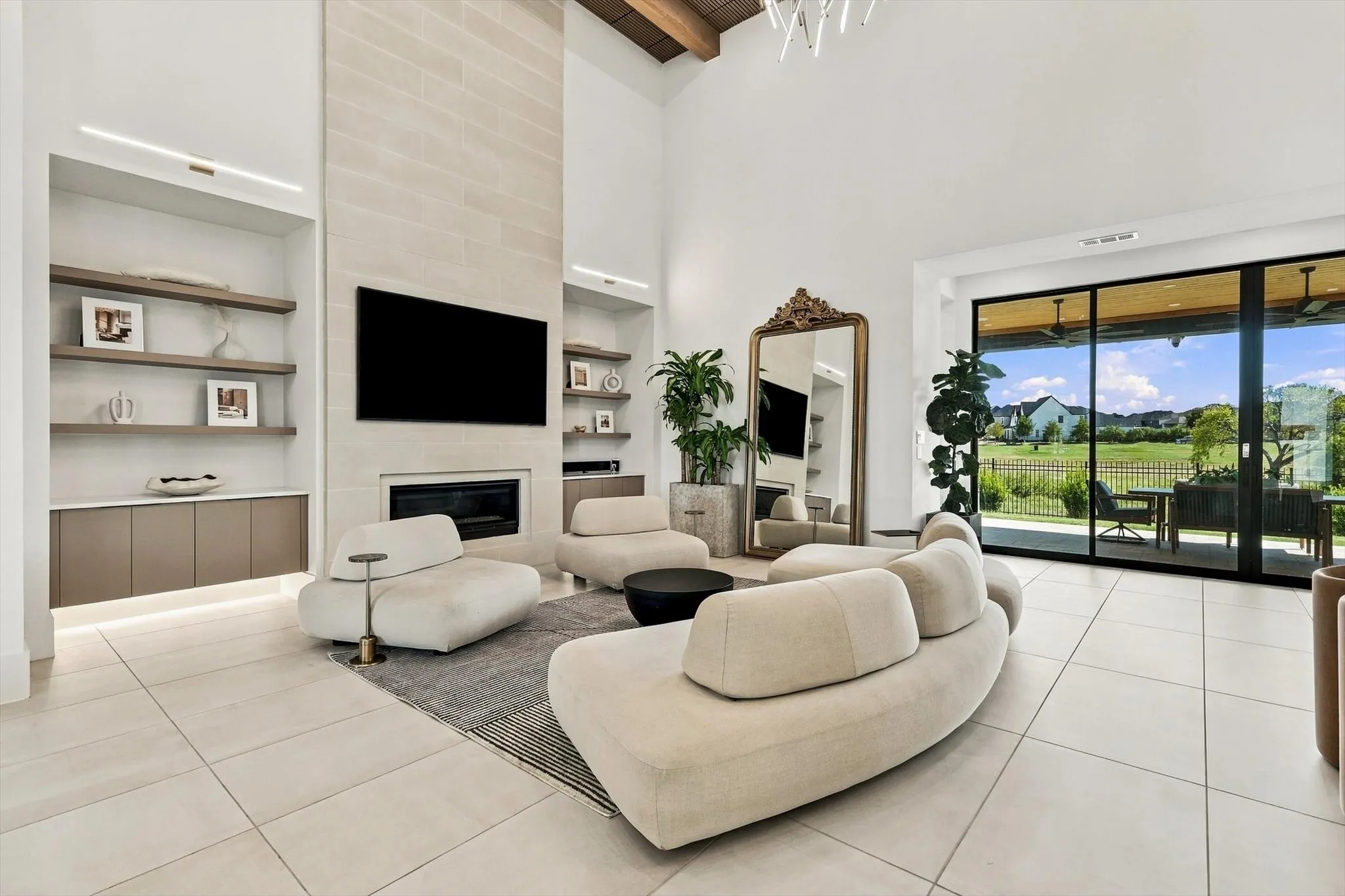 Vaulted ceiling, stone-clad fireplace, built-in shelving, integrated cabinetry, and large sliding glass doors