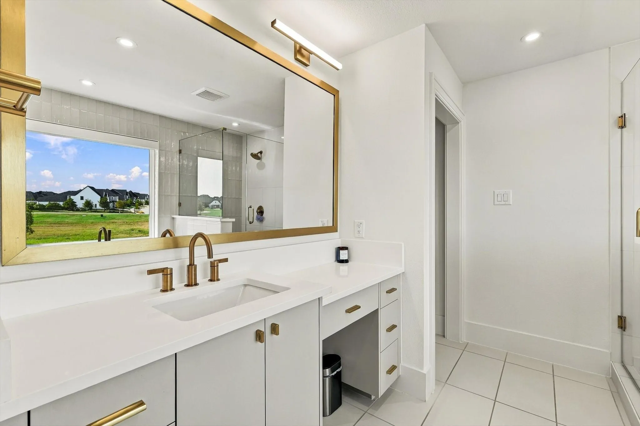 Dual-sink vanity with white countertop, brass fixtures, and integrated storage