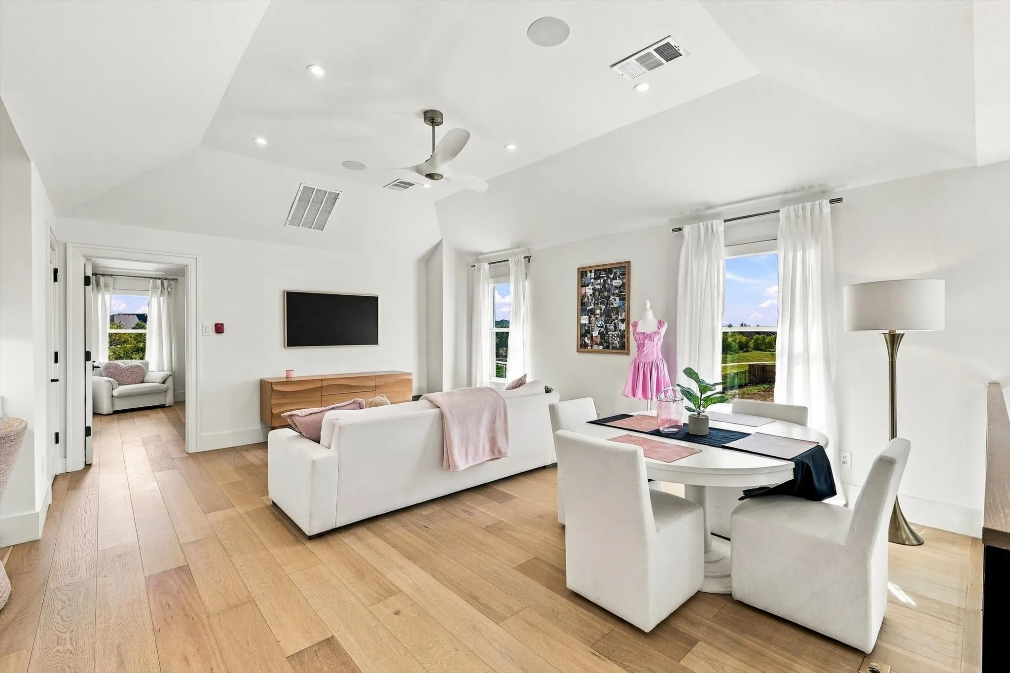Vaulted ceiling with recessed lighting, wood-finish flooring, ceiling fan, and multiple windows
