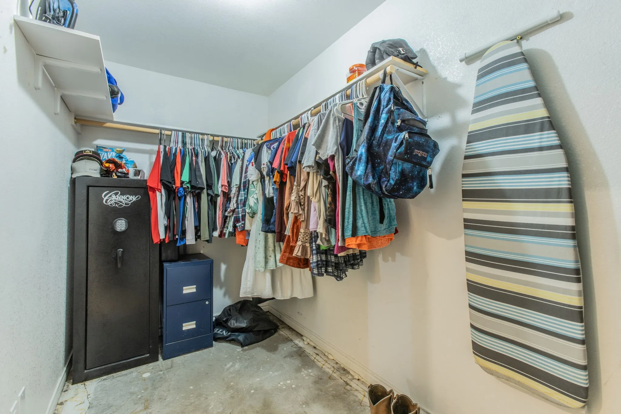 Wall-mounted shelving, built-in hanging rods, and a wall-mounted ironing board