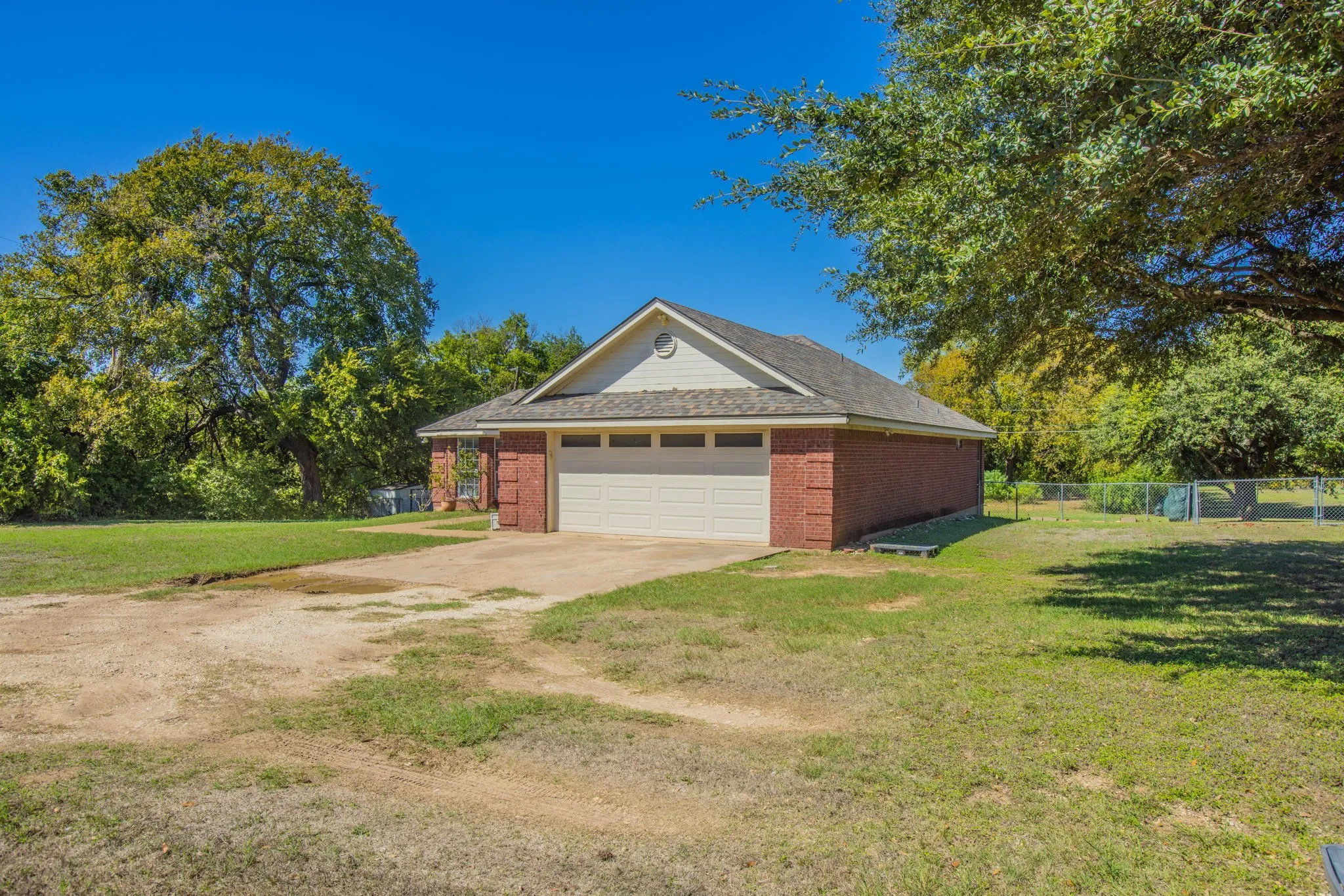 Brick exterior with a peaked gable roofline and an attached garage with a sectional door