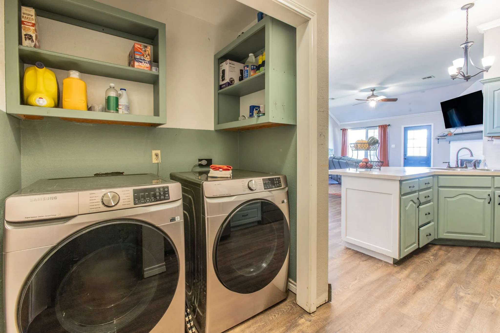 Built-in shelving, wood-finish flooring, light-colored countertops, and light-colored cabinetry