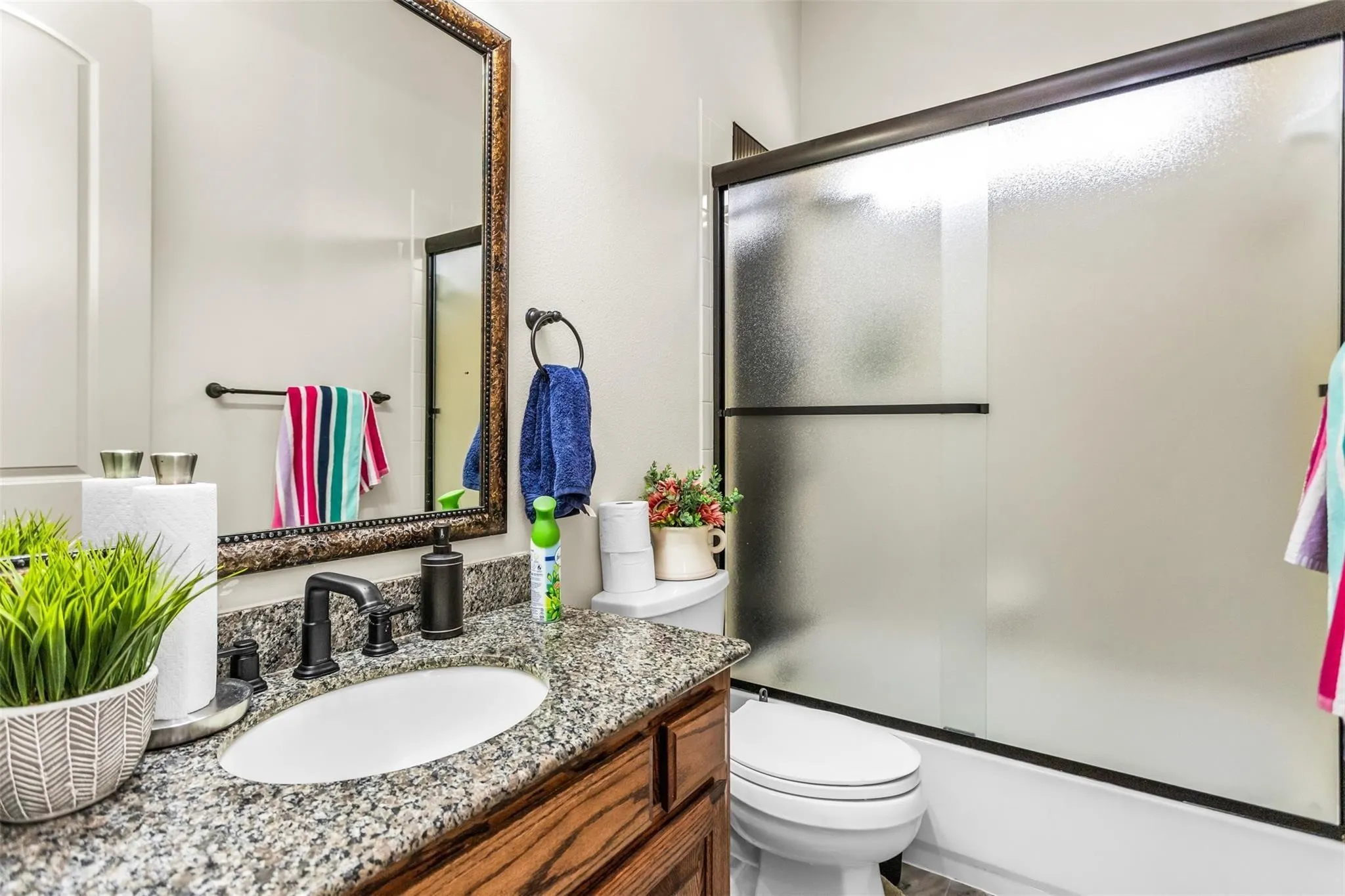 Vanity with granite-style countertop, oval sink, and dark bronze-finish faucet