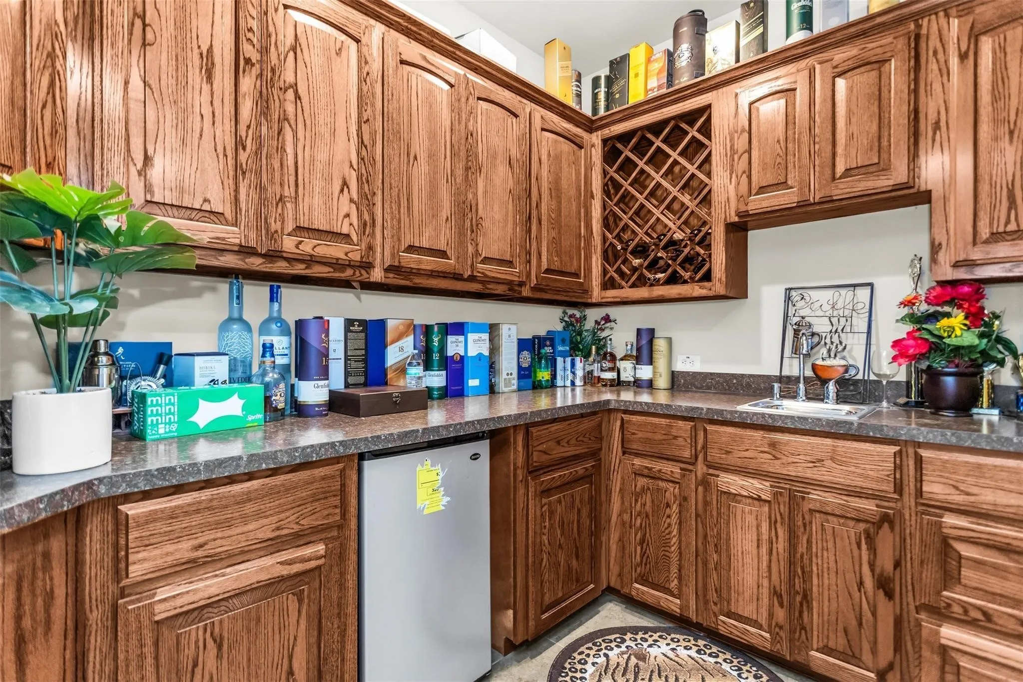 Wood-finish cabinetry with integrated wine storage, patterned countertops, and a built-in beverage refrigerator