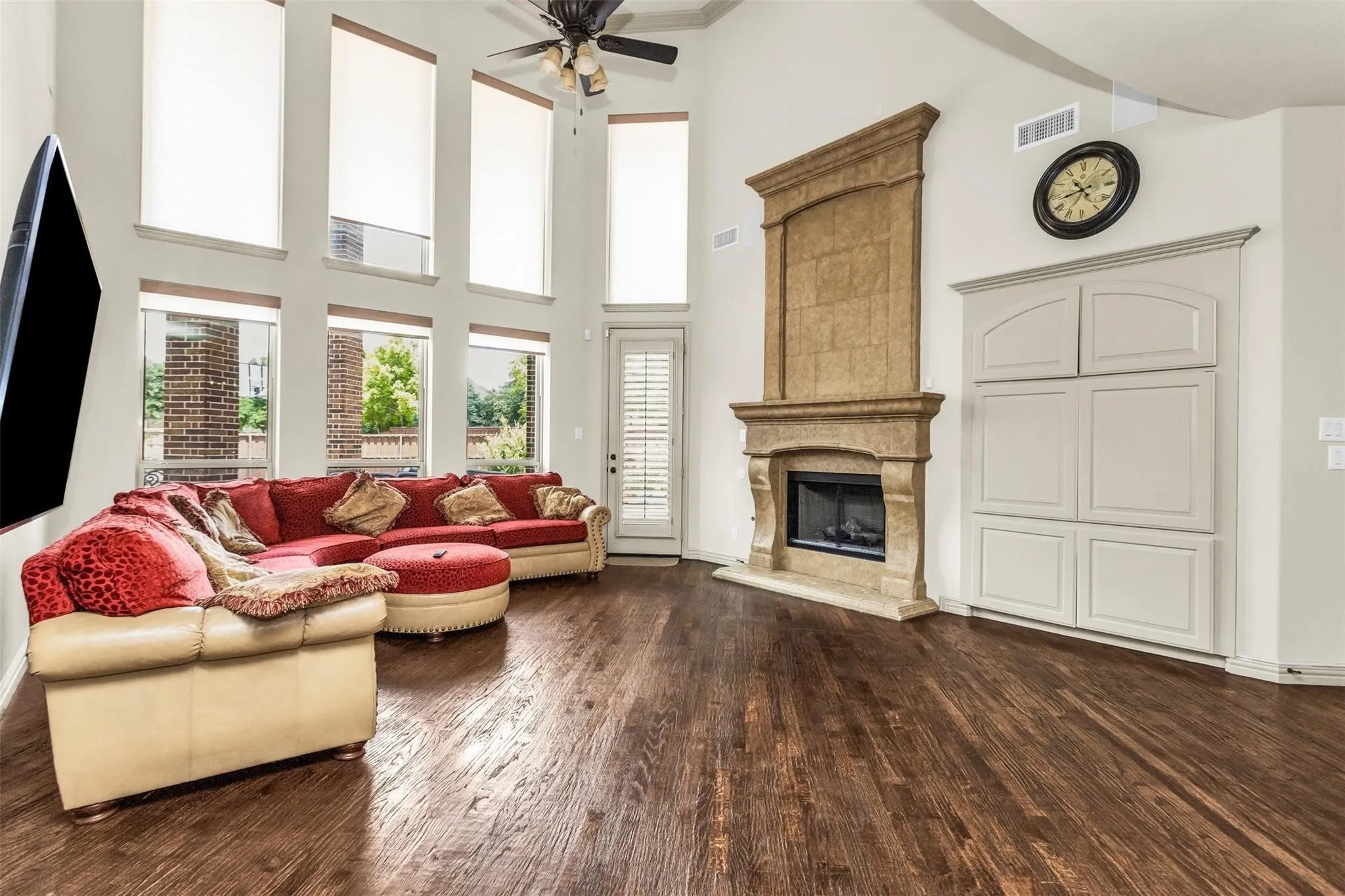 Vaulted ceilings, wood-finish flooring, a stone-clad fireplace, and built-in cabinetry
