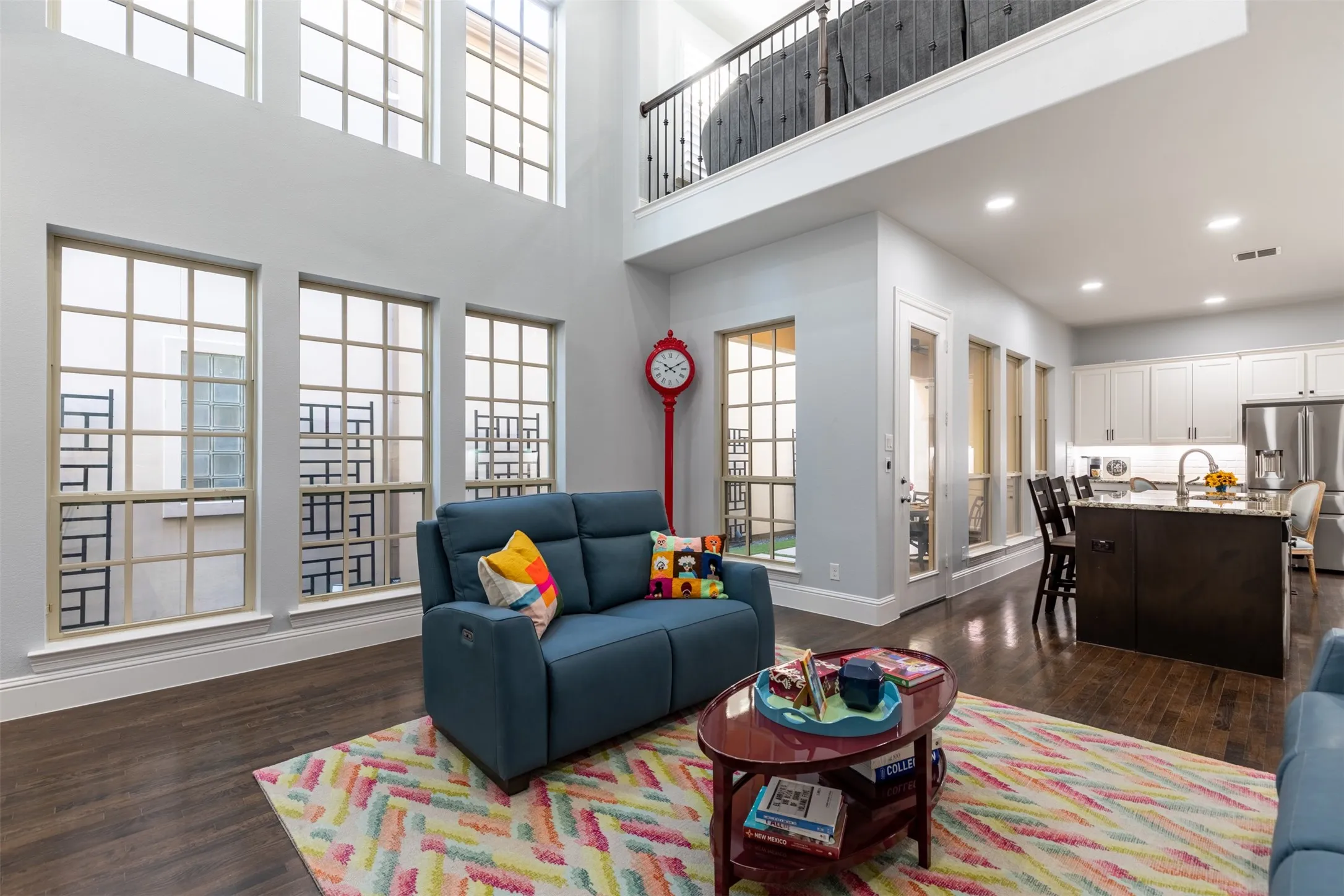 Living room with stacked windows providing natural light.