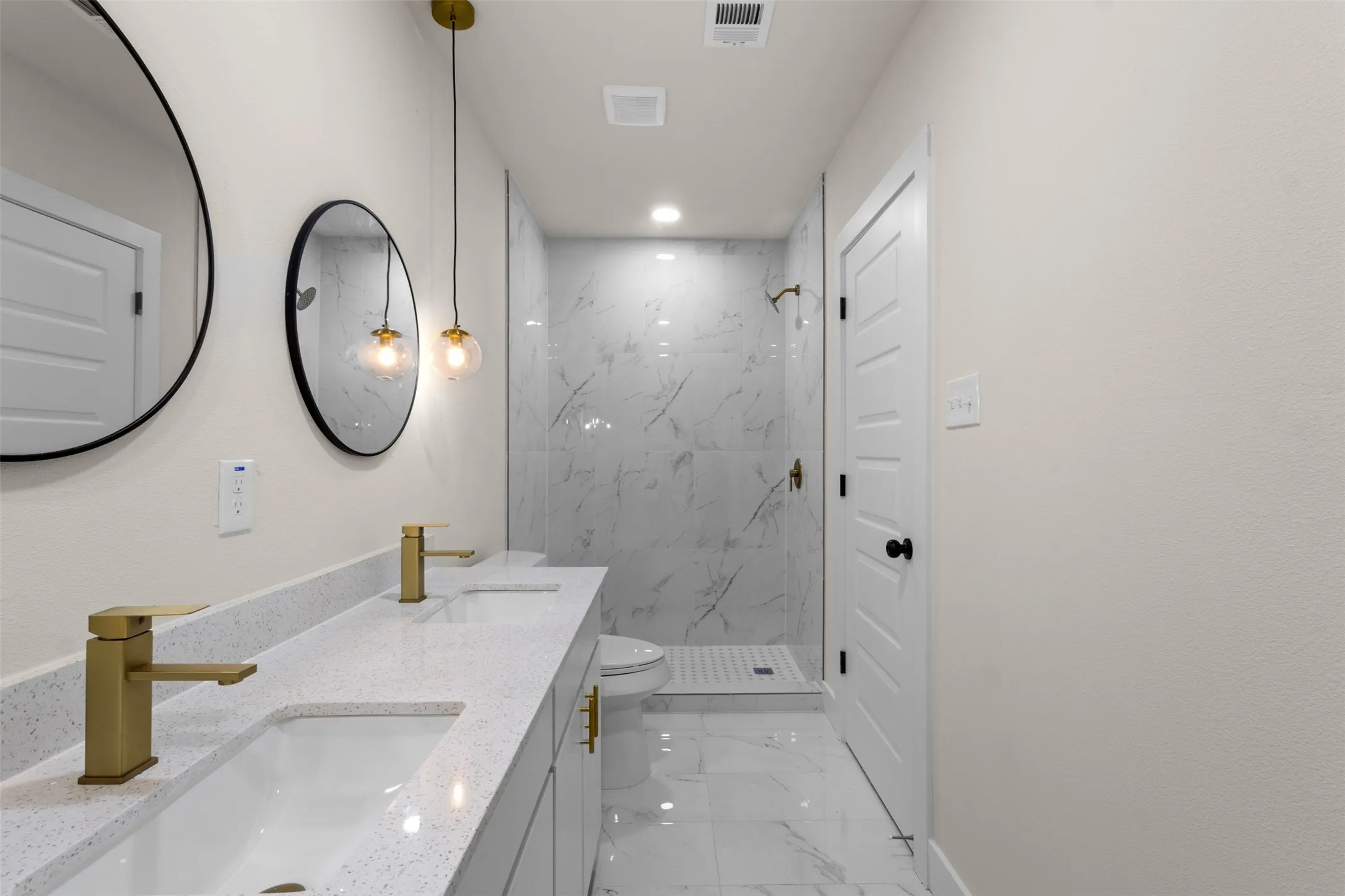Dual vanity with gold-tone fixtures and integrated sinks