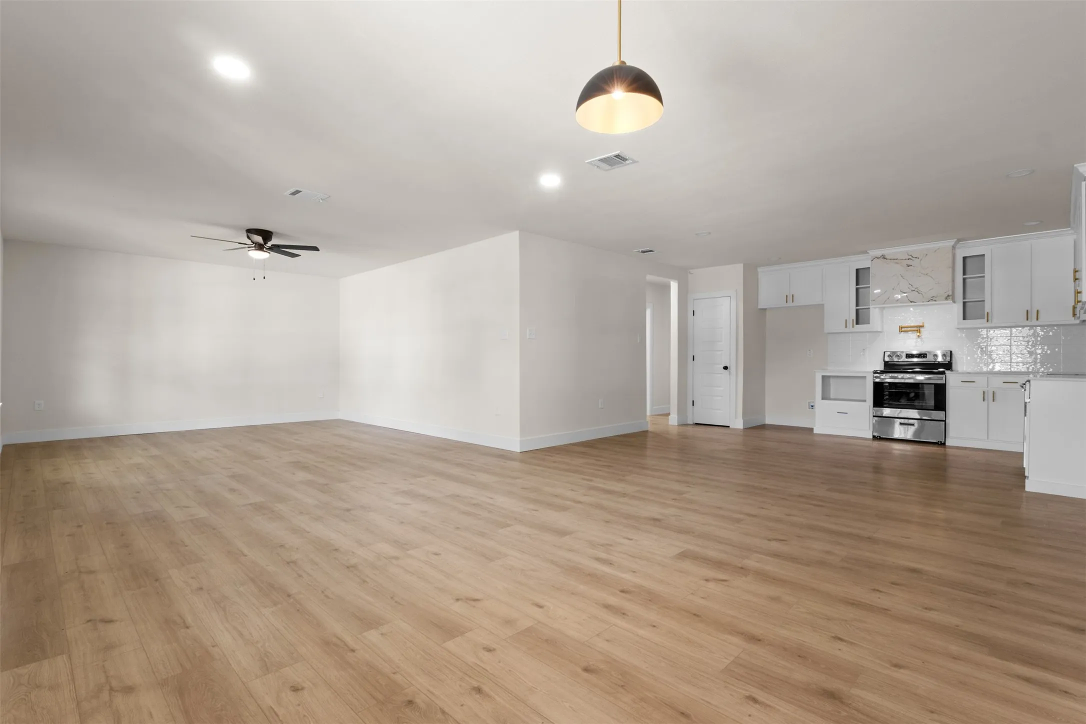 Open-concept living area featuring wood-finish flooring, recessed lighting, and a ceiling fan