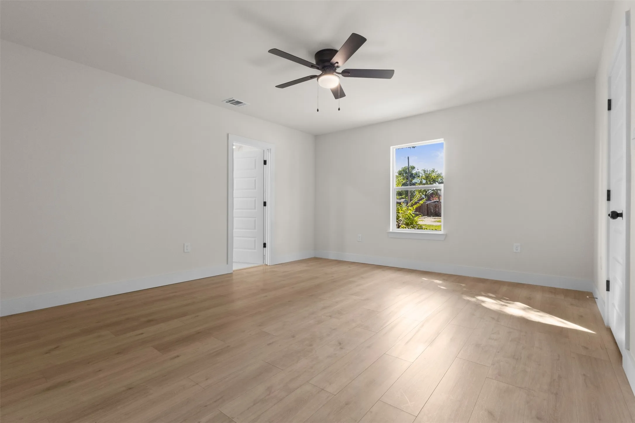 Light wood-finish flooring with white walls