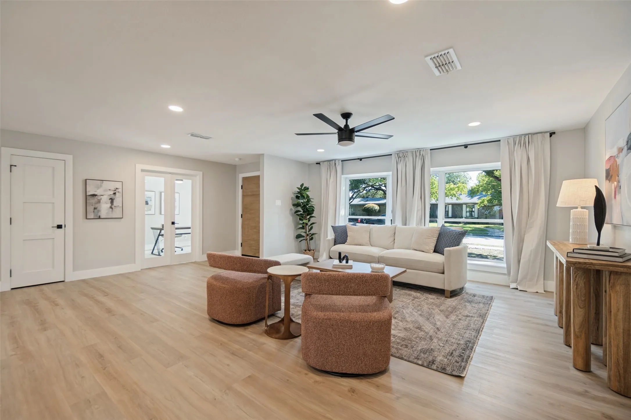 Recessed lighting, wood-finish flooring, ceiling fan, and large windows with privacy drapes