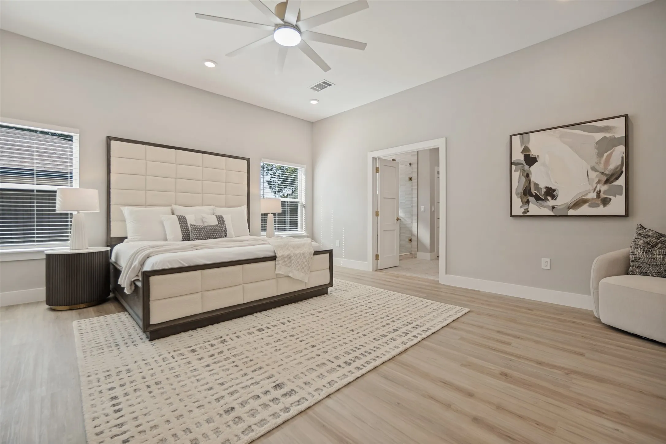 Light wood-finish flooring, recessed lighting, ceiling fan, and white trim throughout