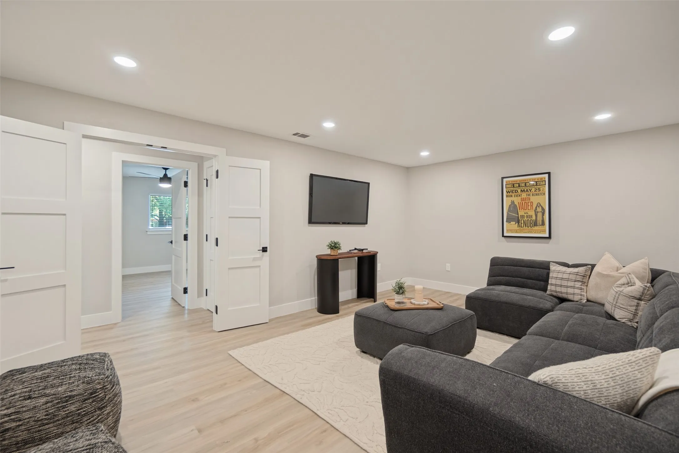 Recessed lighting, wood-finish flooring, white paneled doors, and light-toned walls