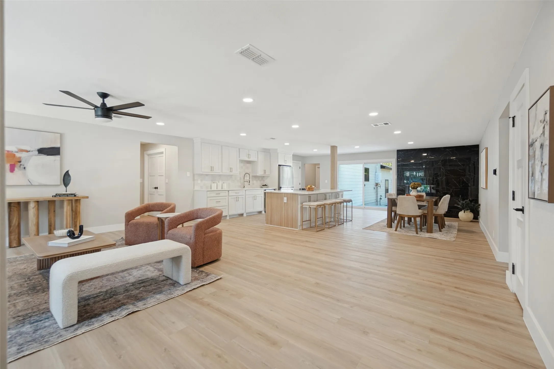 Open-concept living space featuring wood-finish flooring, recessed lighting, and a modern ceiling fan