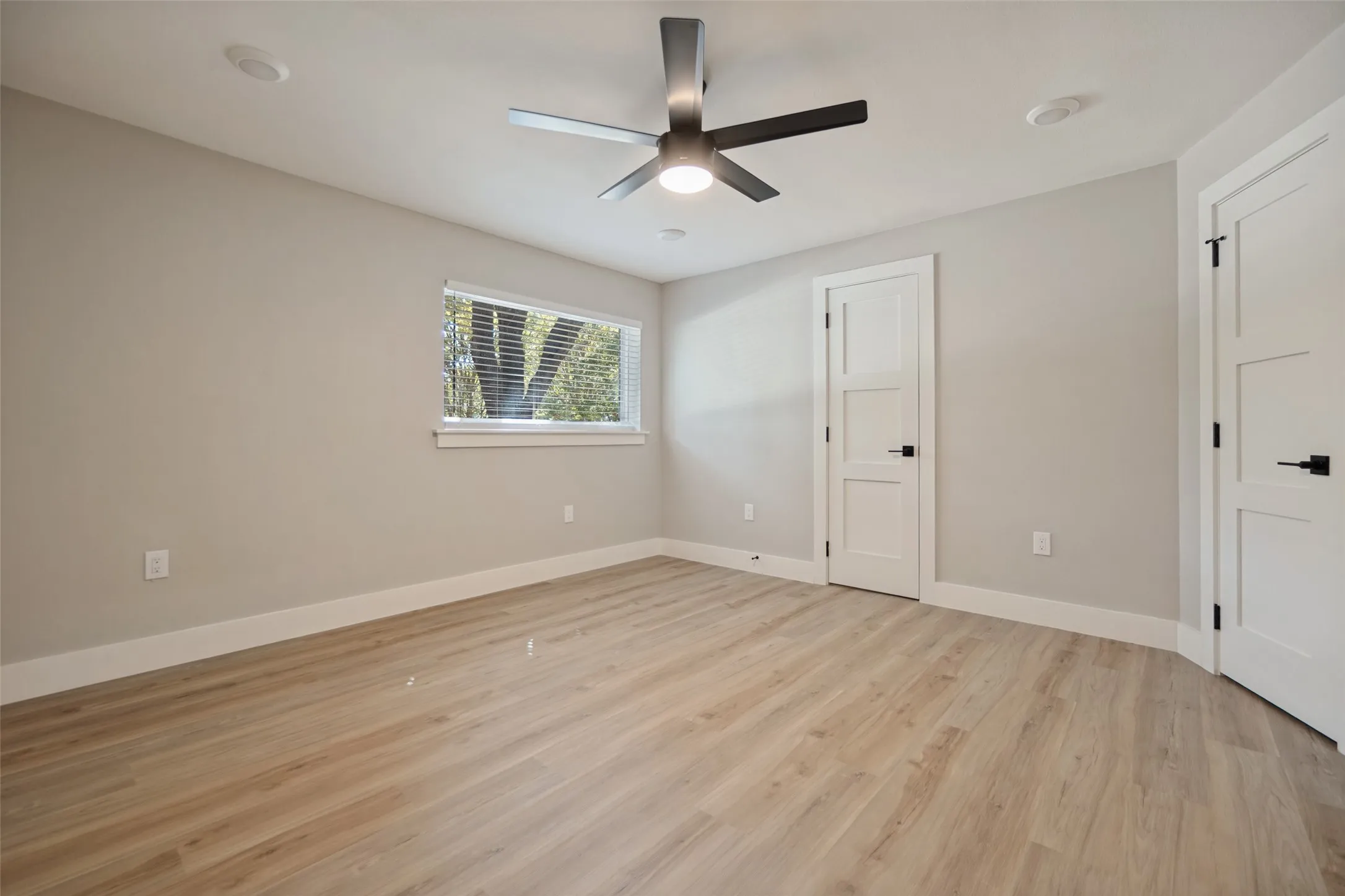 Light wood-finish flooring, neutral wall paint, and white trim throughout
