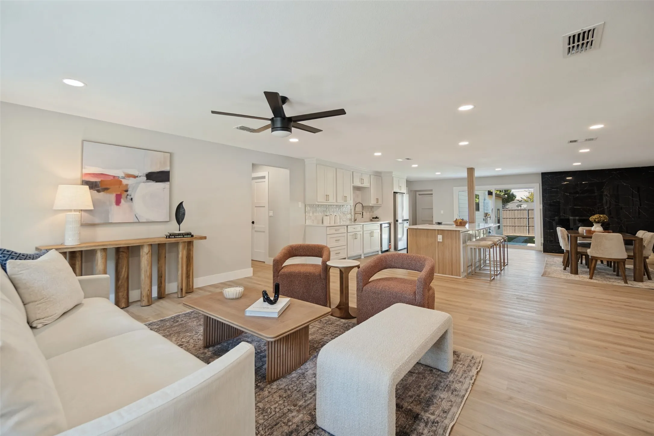 Open-concept living space featuring wood-finish flooring, recessed lighting, and a contemporary ceiling fan