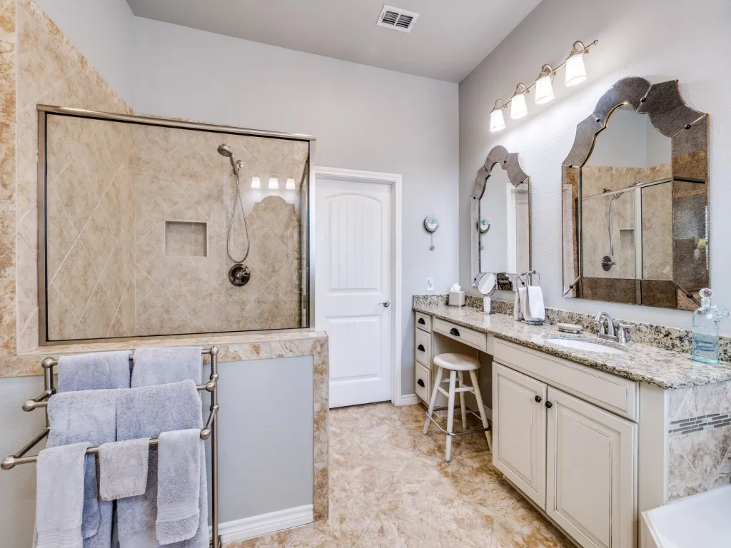 The spacious primary bath features split his-and-hers vanities, a relaxing garden tub, and a separate shower.