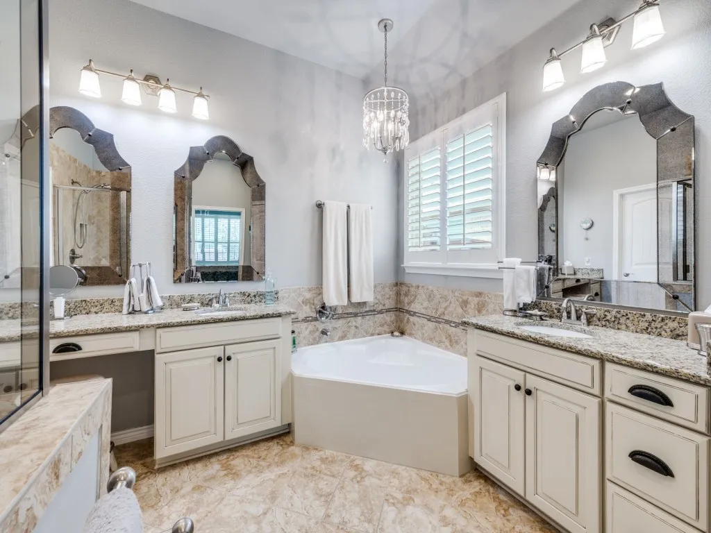 The spacious primary bath features split his-and-hers vanities, a relaxing garden tub, and a separate shower.