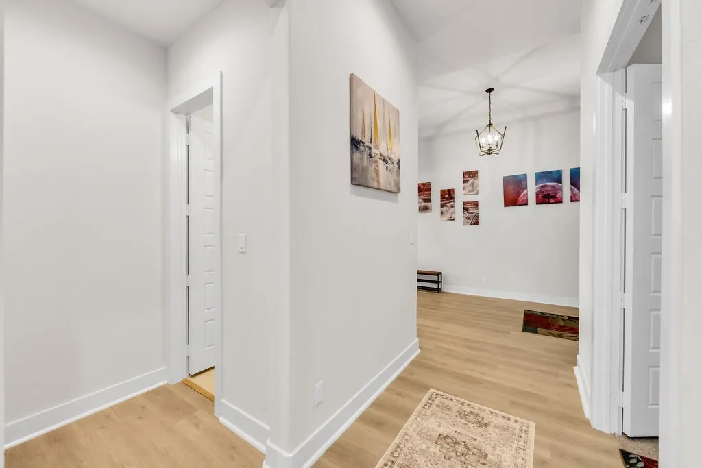 Wood-finish flooring throughout, white walls, and a recessed doorway