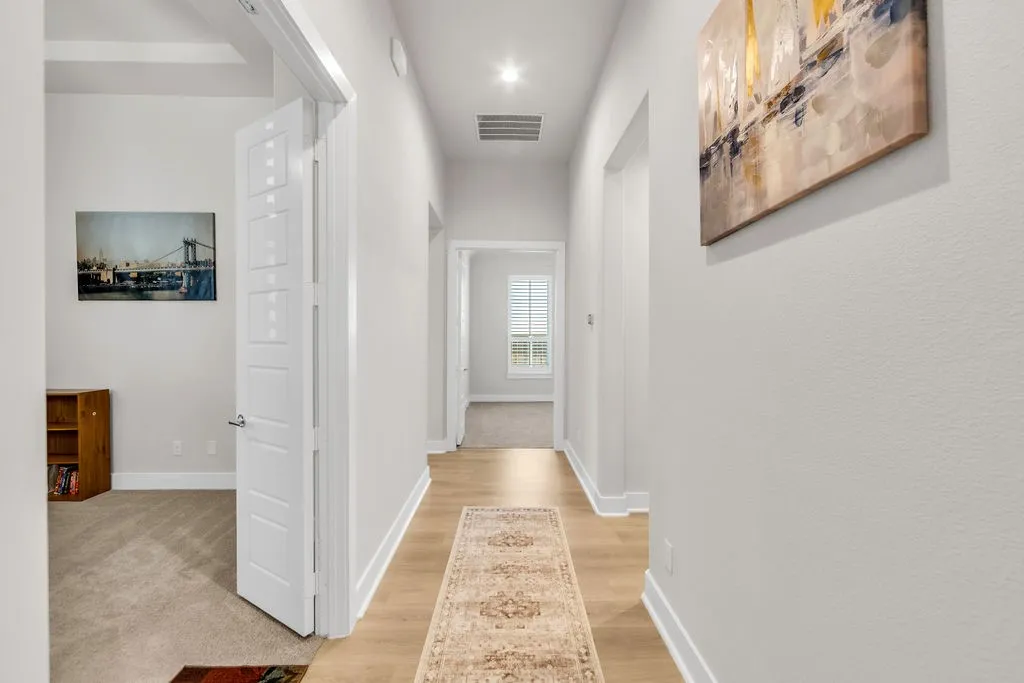 Recessed lighting illuminates wood-finish flooring