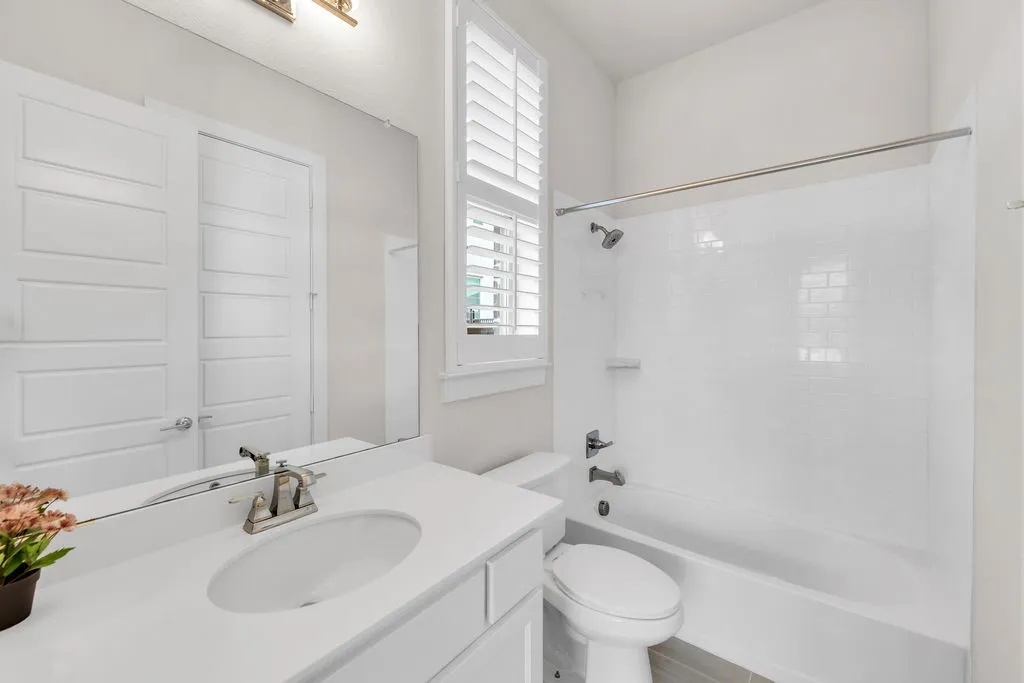 White shaker vanity with an integrated sink, brushed nickel faucet, and a large wall-mounted mirror