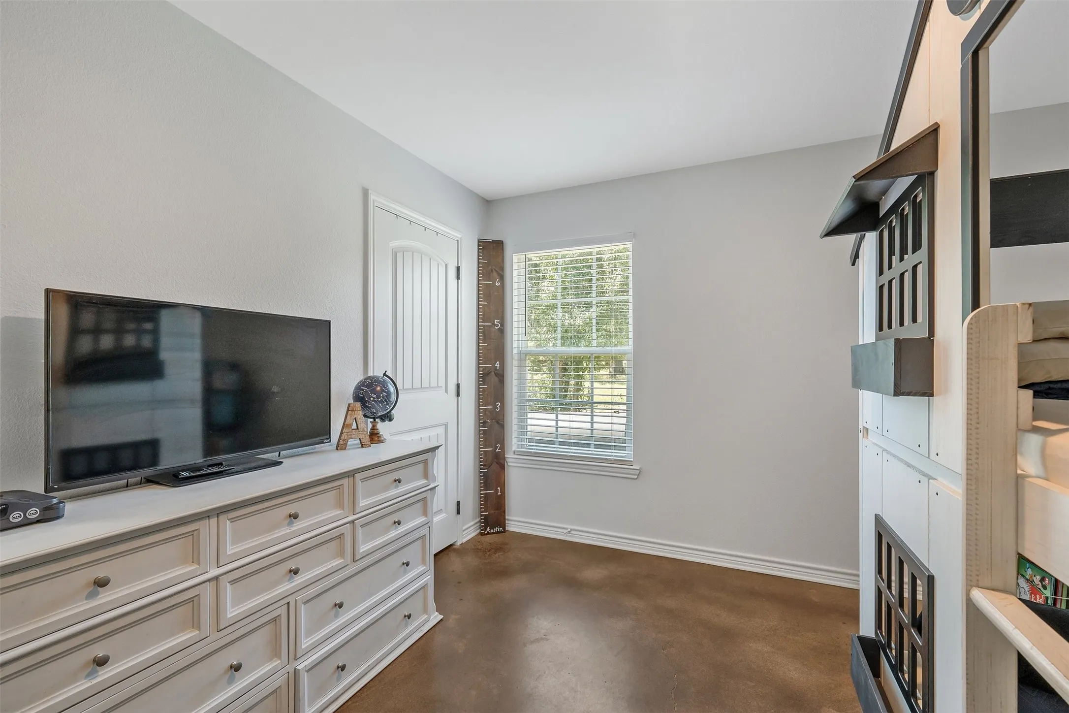 Neutral wall paint, wood-finish flooring, white trim, and a white paneled door