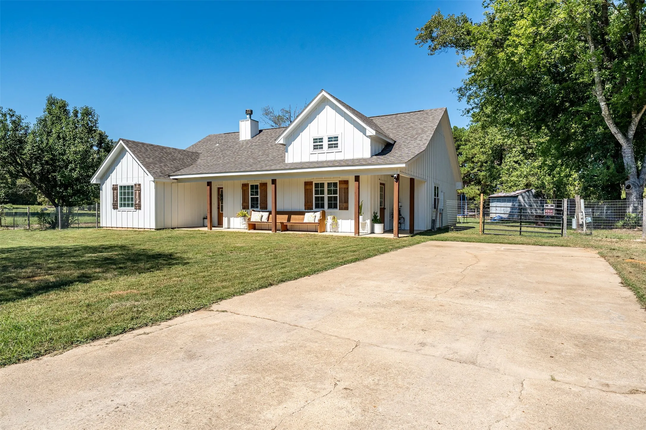 White board and batten exterior with a covered porch, wood columns, and a gabled roof