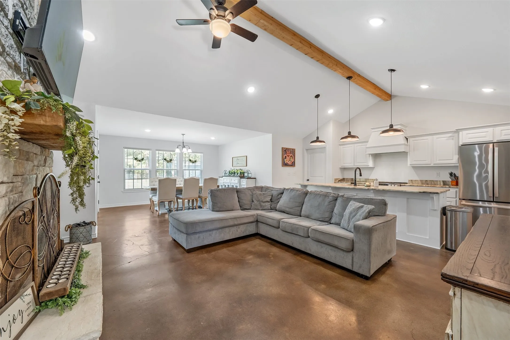 Vaulted ceiling with an exposed wood beam, recessed lighting, and a ceiling fan