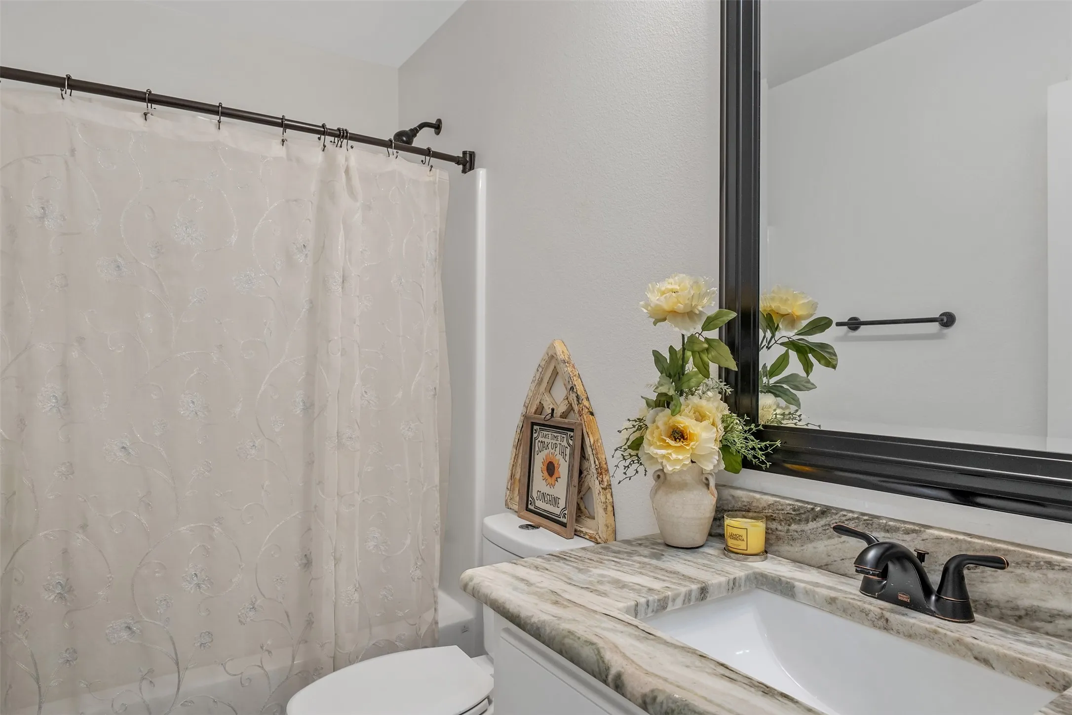 Integrated vanity with an undermount sink, patterned countertop, and a dark-toned faucet