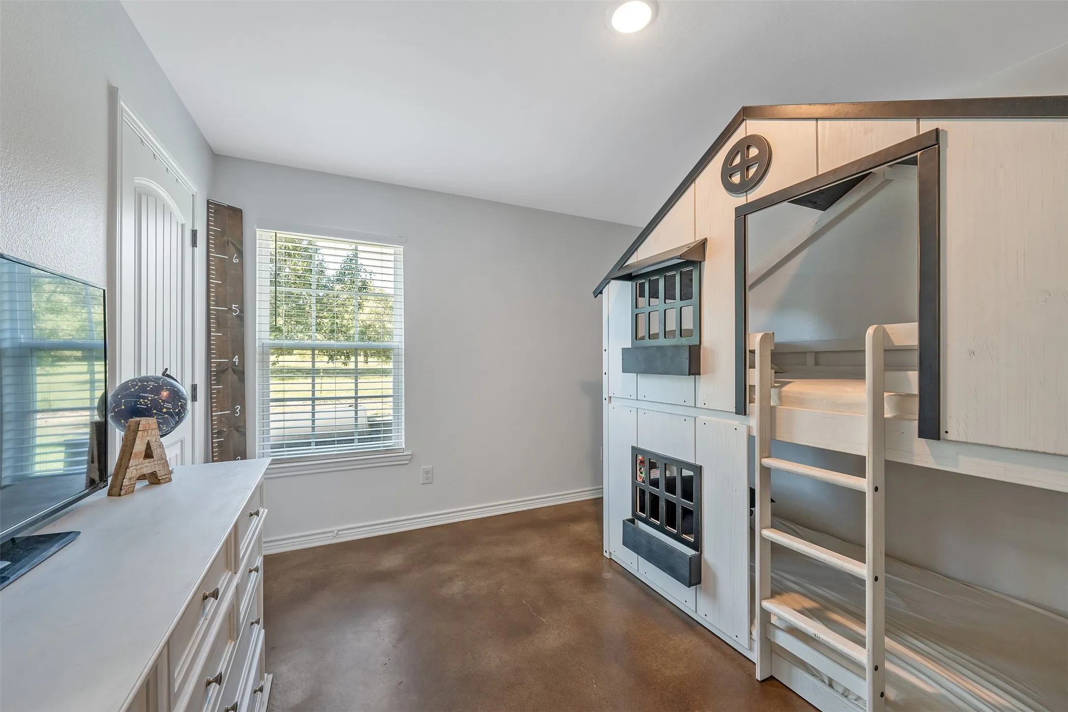 Window with horizontal blinds, built-in bunk bed structure, wood-finish flooring, white trim details, and recessed ceiling lighting