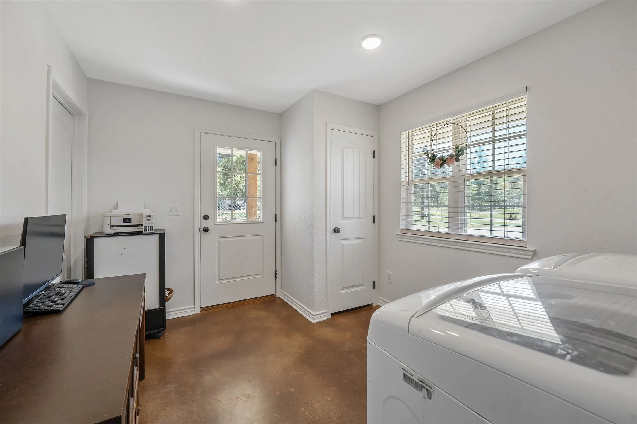 Recessed lighting, a window with horizontal blinds, a white paneled door, and a glass-paneled door