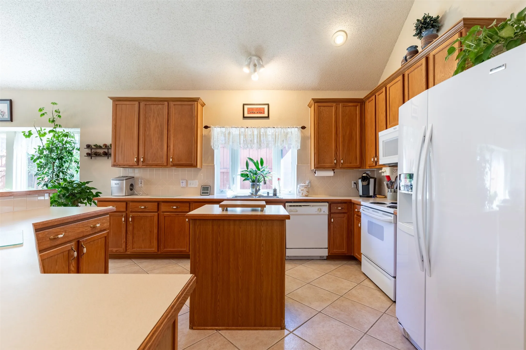 Kitchen with white appliances and natural light.