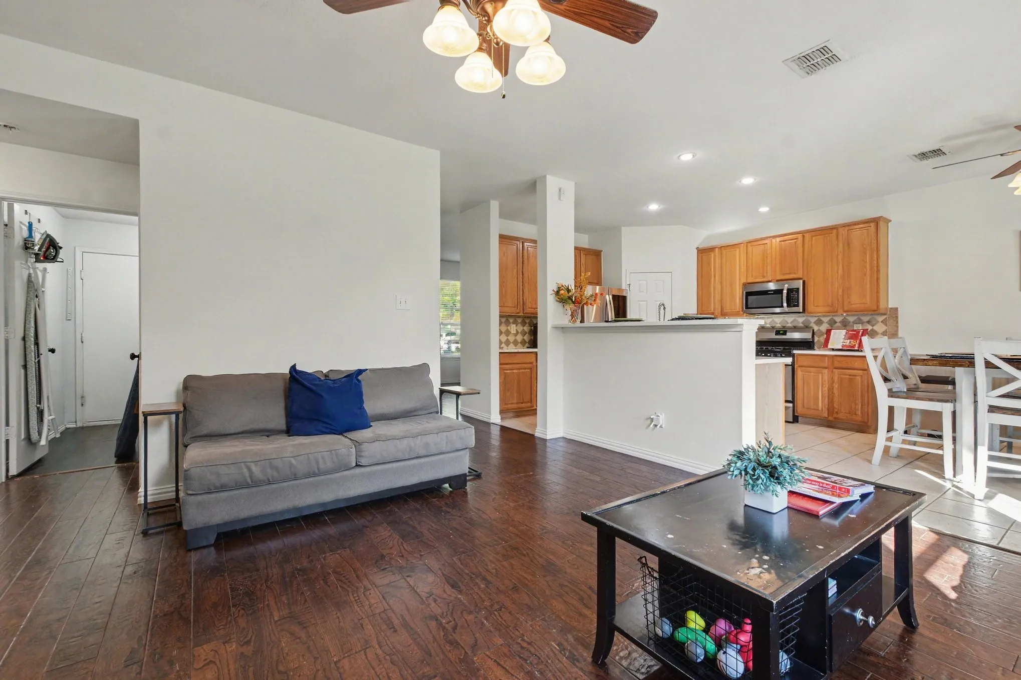 Wood-finish flooring throughout, recessed lighting, and a ceiling fan
