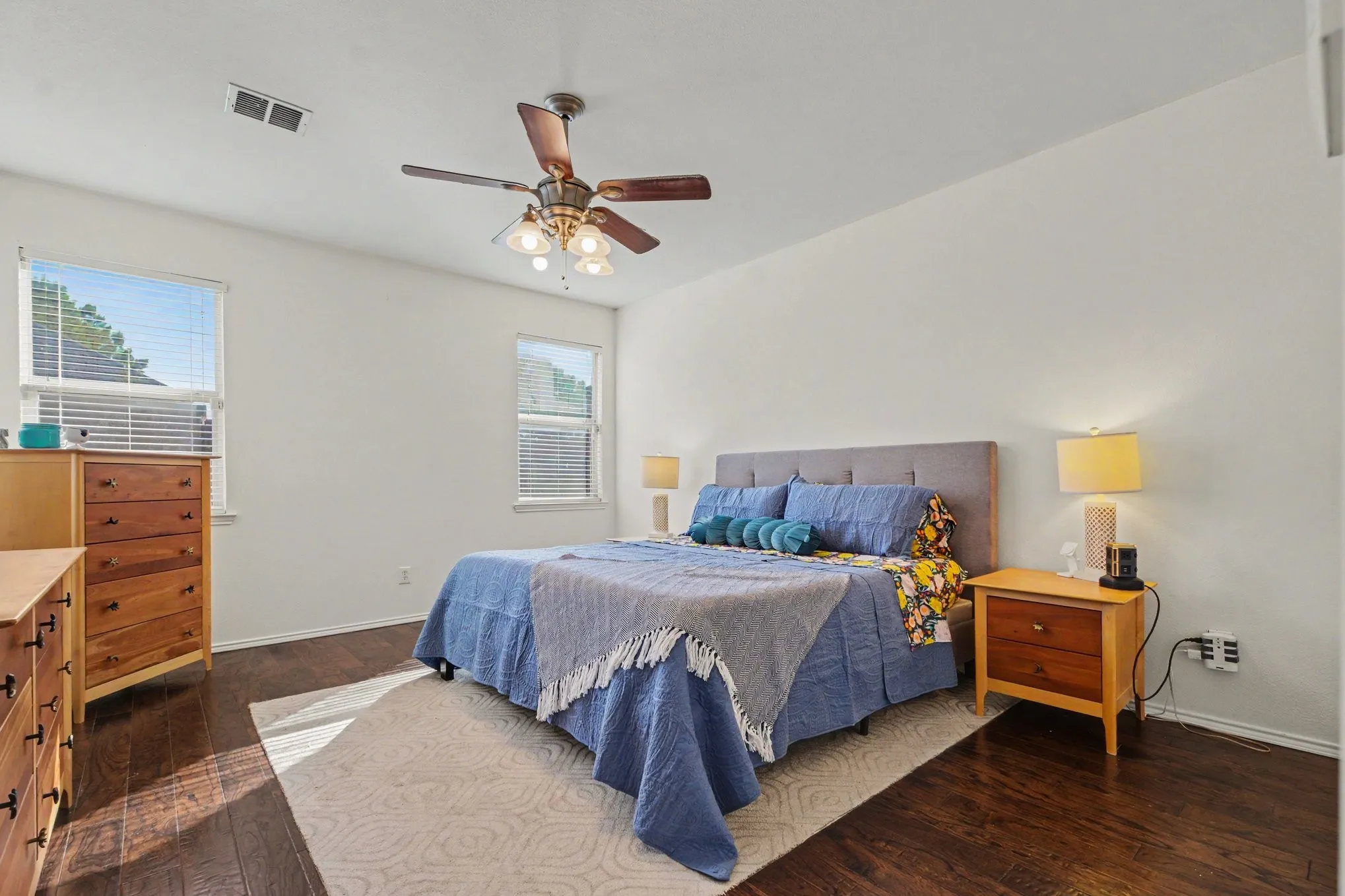 Hardwood-finish flooring, white wall tones, and two windows with blinds