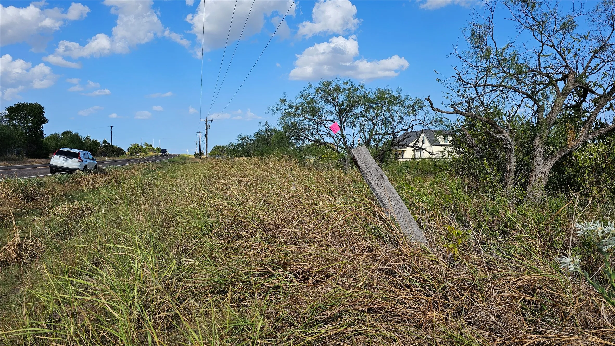 Looking toward northeast from the estimated boundary on the road frontage marked by fence post with flag marker.