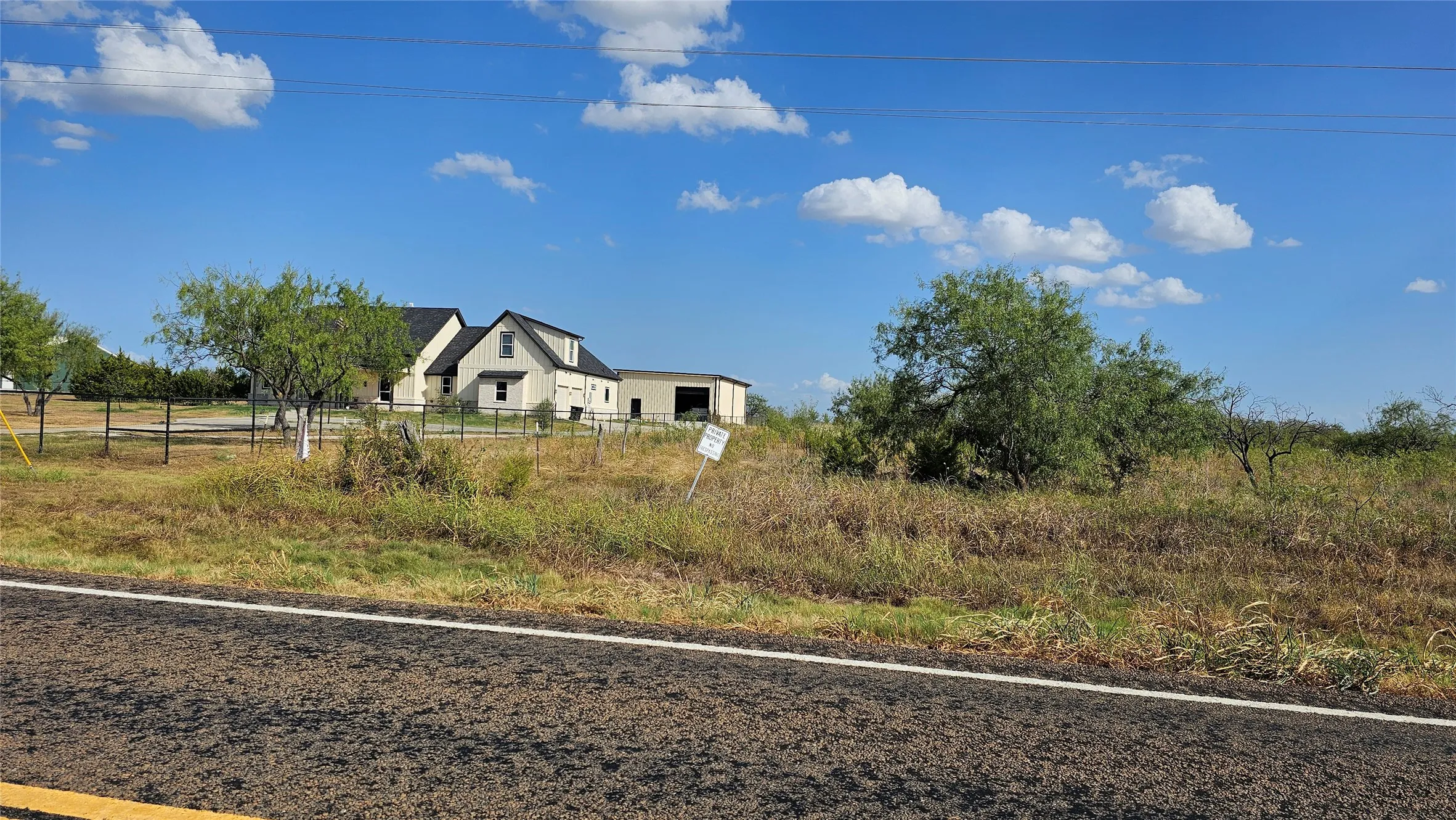 View from the road looking east with neighboring custom-built home.