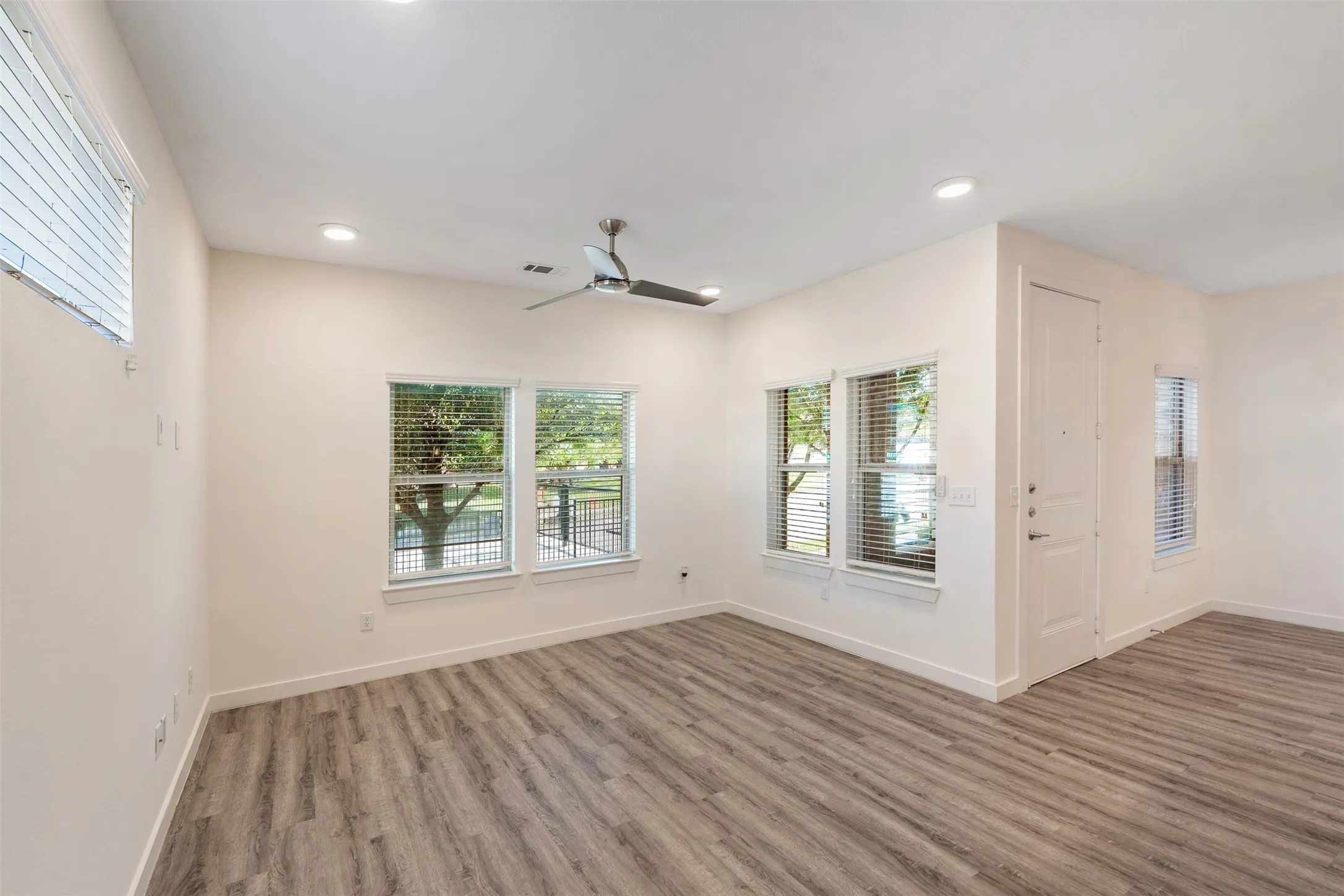 Wood-finish flooring throughout, recessed lighting, and a contemporary ceiling fan