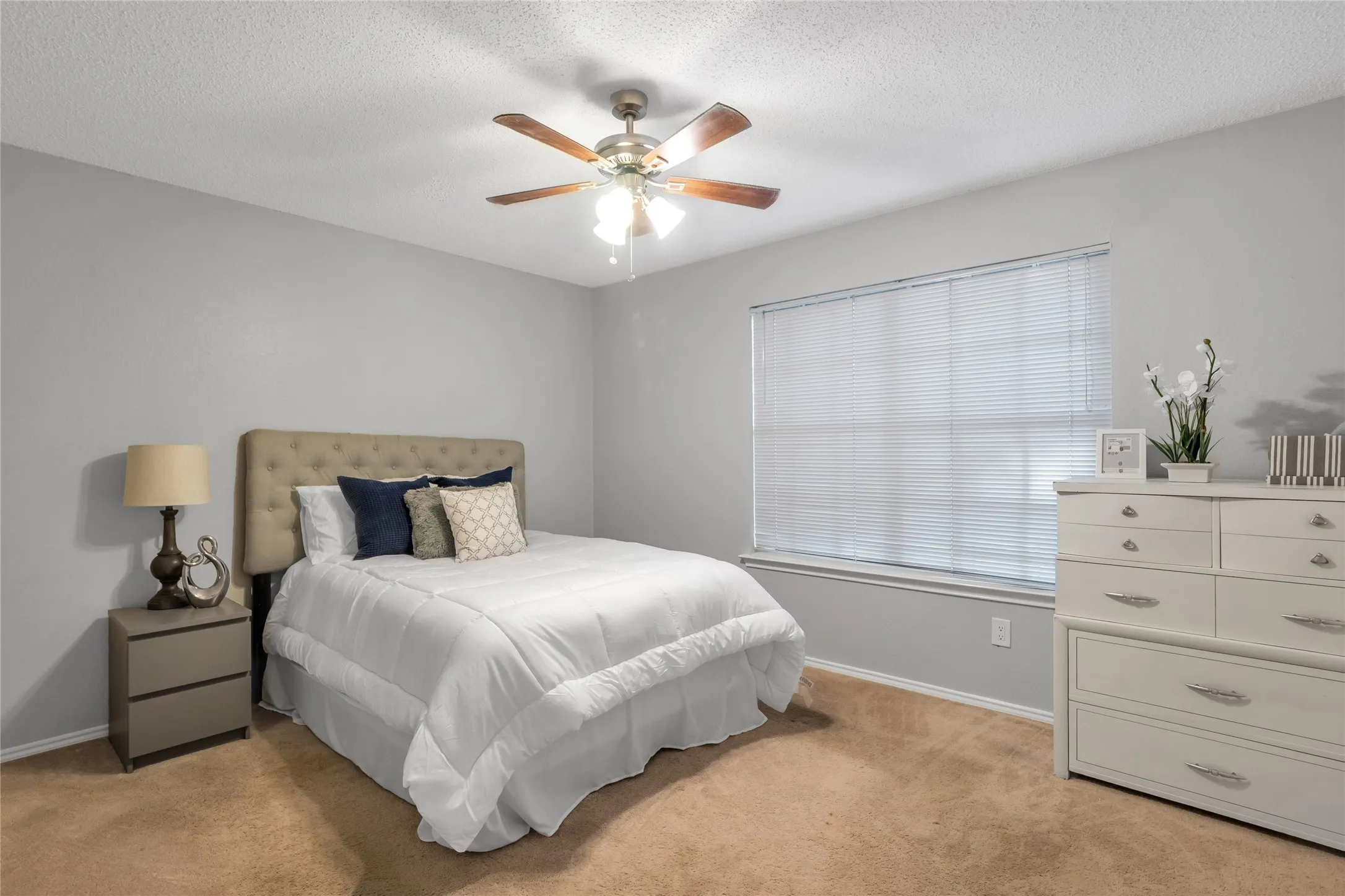 Bedroom with a ceiling fan, window with blinds, and neutral-toned wall paint