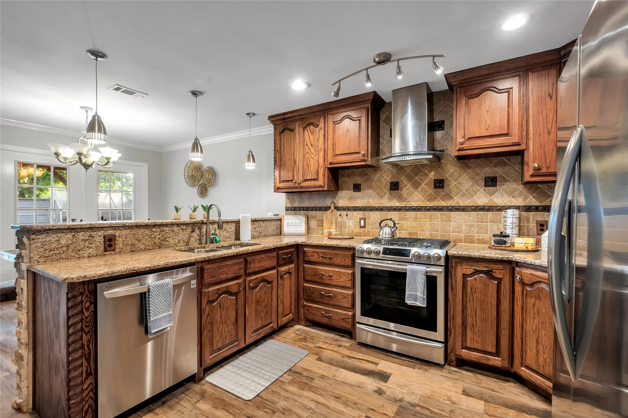 Wood-finish flooring, granite countertops, stainless steel appliances, wood cabinetry, and a tile backsplash