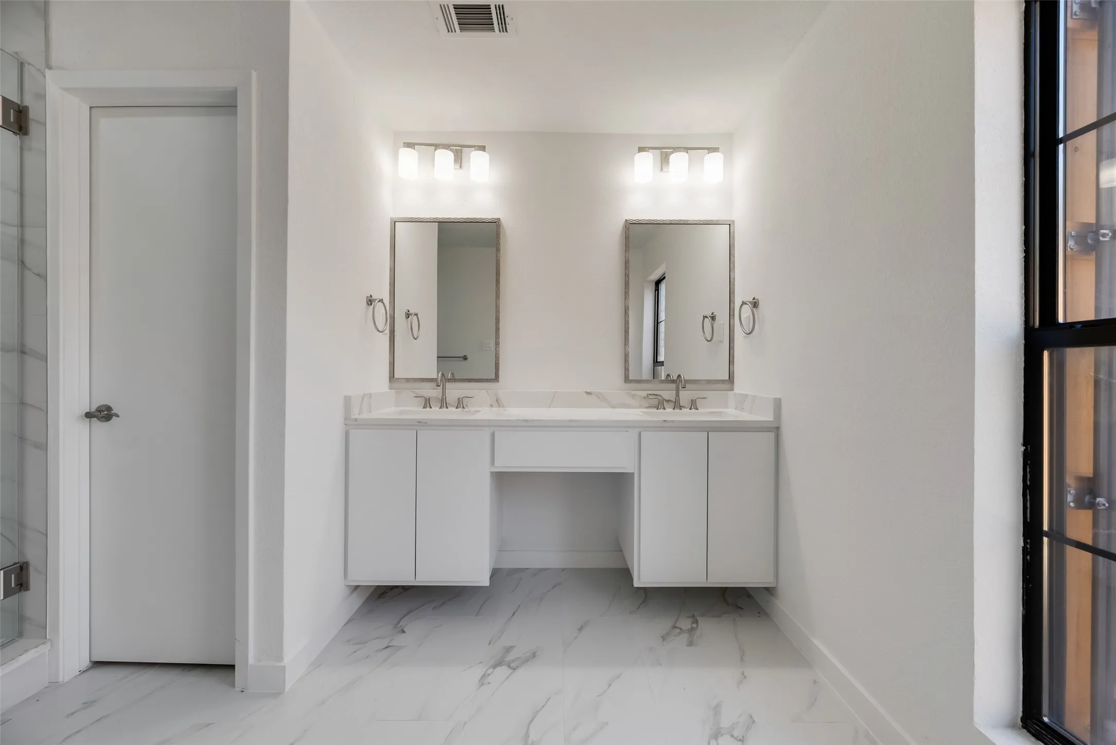 Dual floating vanities with undermount sinks and light-colored countertops