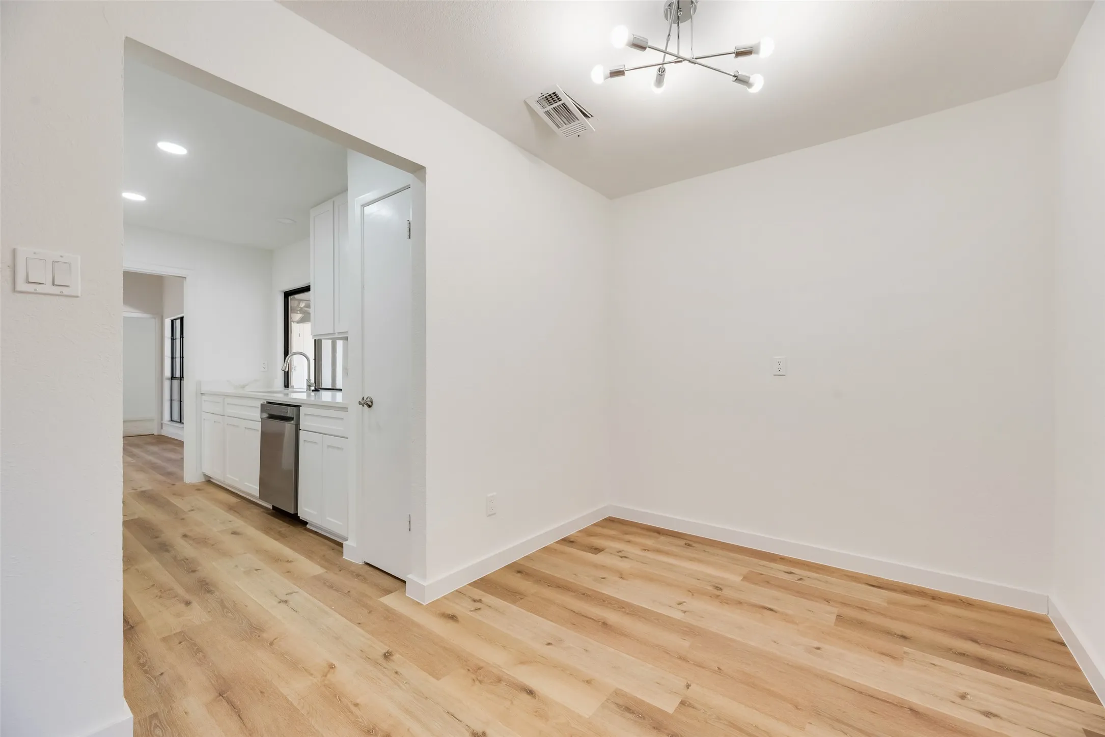 Wood-finish flooring throughout, with a contemporary ceiling fixture and recessed lighting