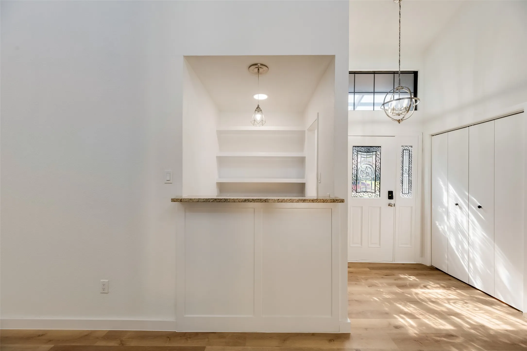 Vaulted entry with decorative glass door and transom window